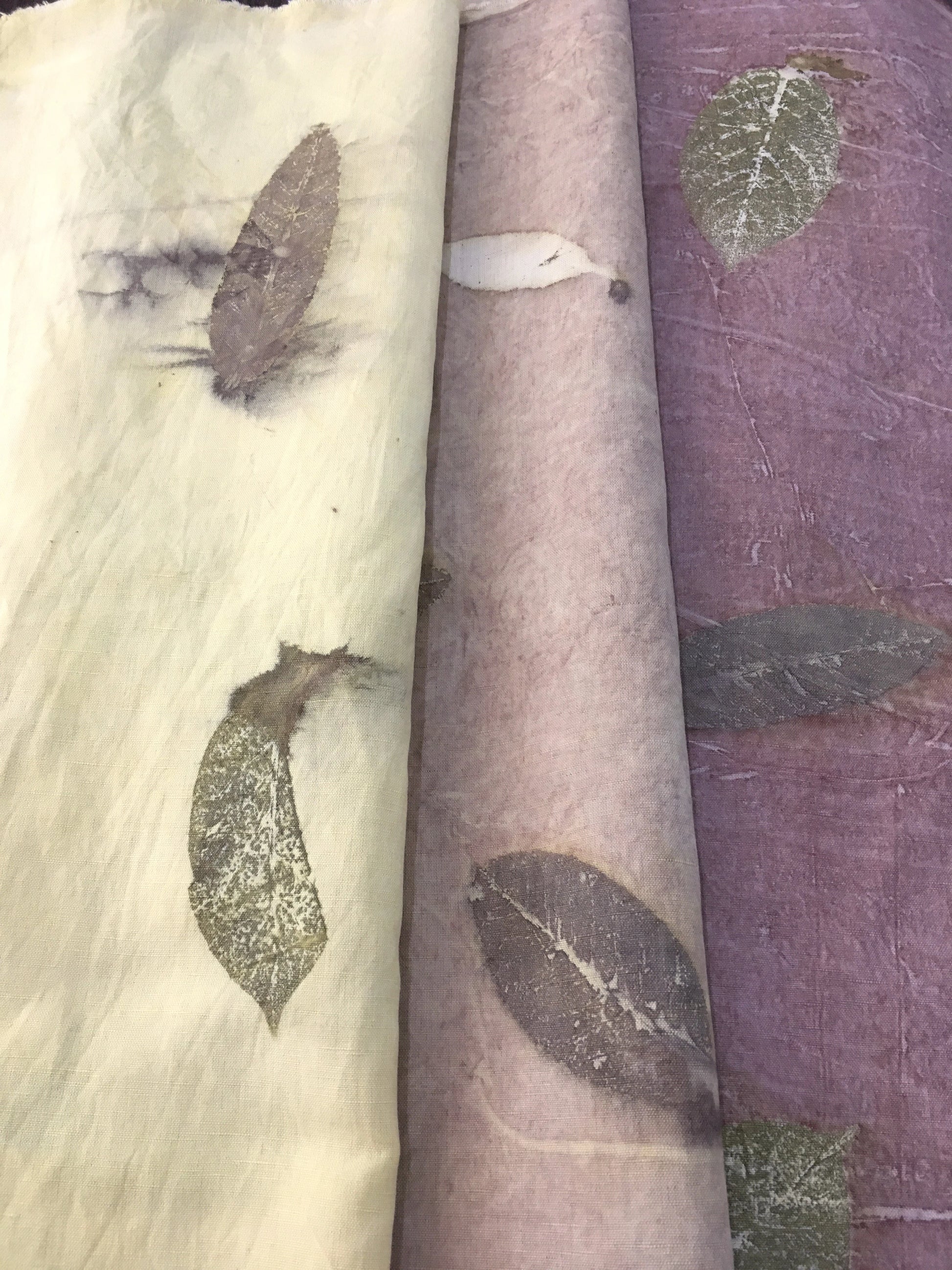 Three rolls of Linen Blend Handmade Ecoprinted Fabric with leaf patterns in different colors.
