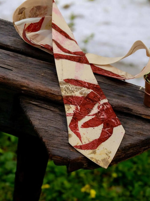 Marbled red and beige tie on a wooden surface with a natural background