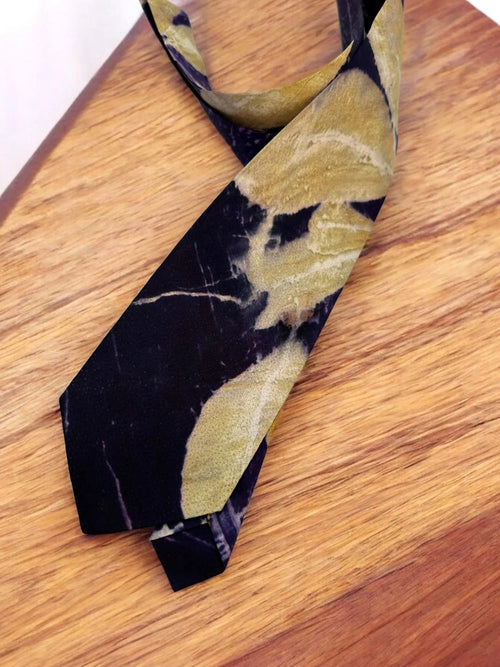 Black and gold Pure silk mens tie on a wooden surface