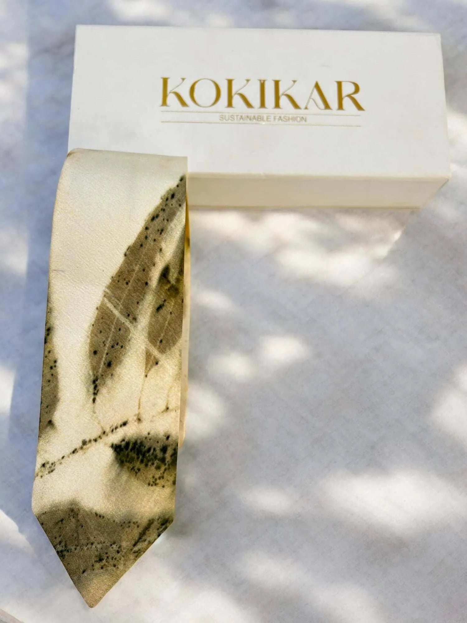 Pure silk mens tie with a leaf pattern on a white background, featuring the brand 'Kokikar'.