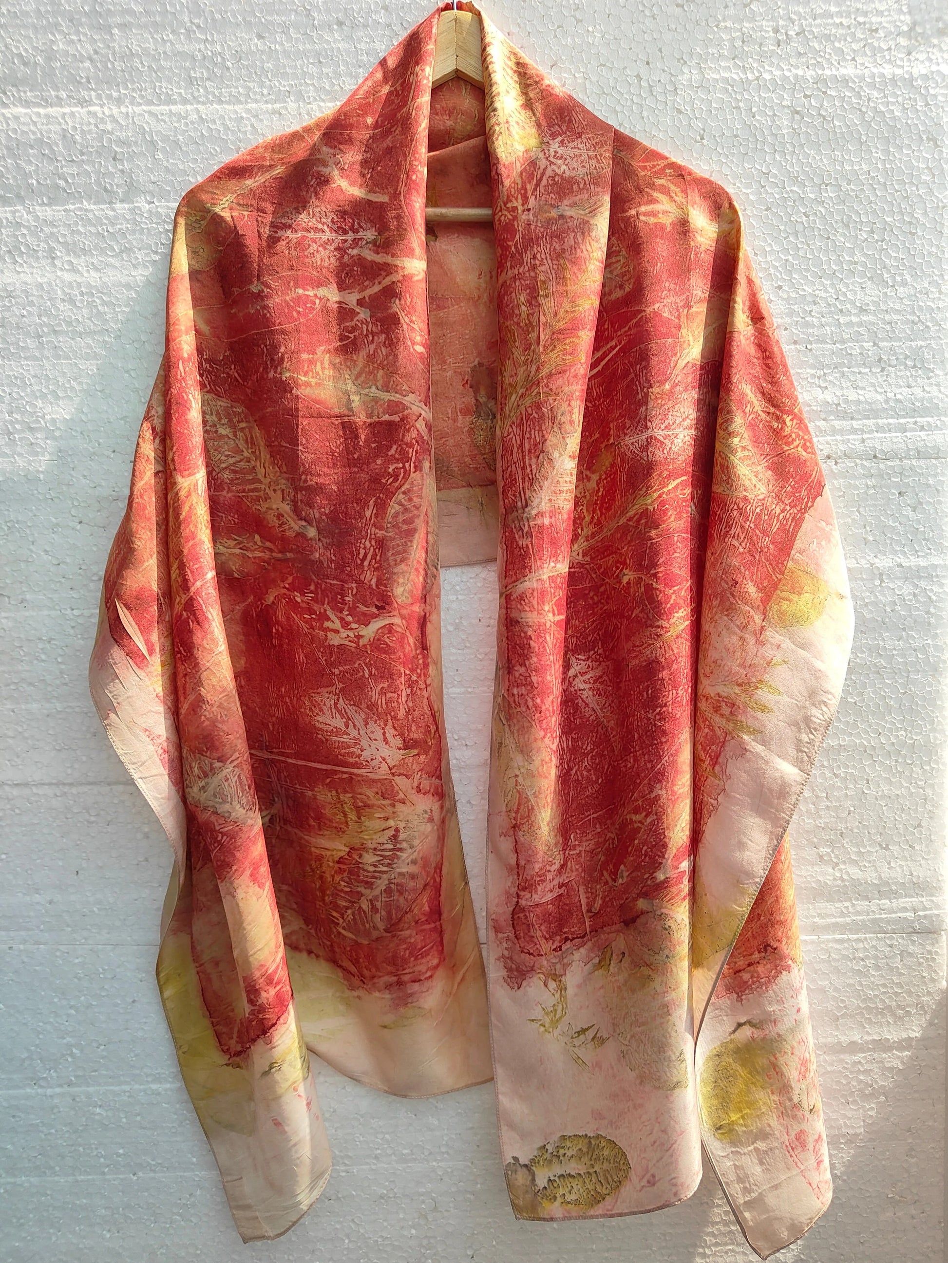 Red Charm Ecoprinted Pure Silk Scarf with abstract pattern draped over a white surface