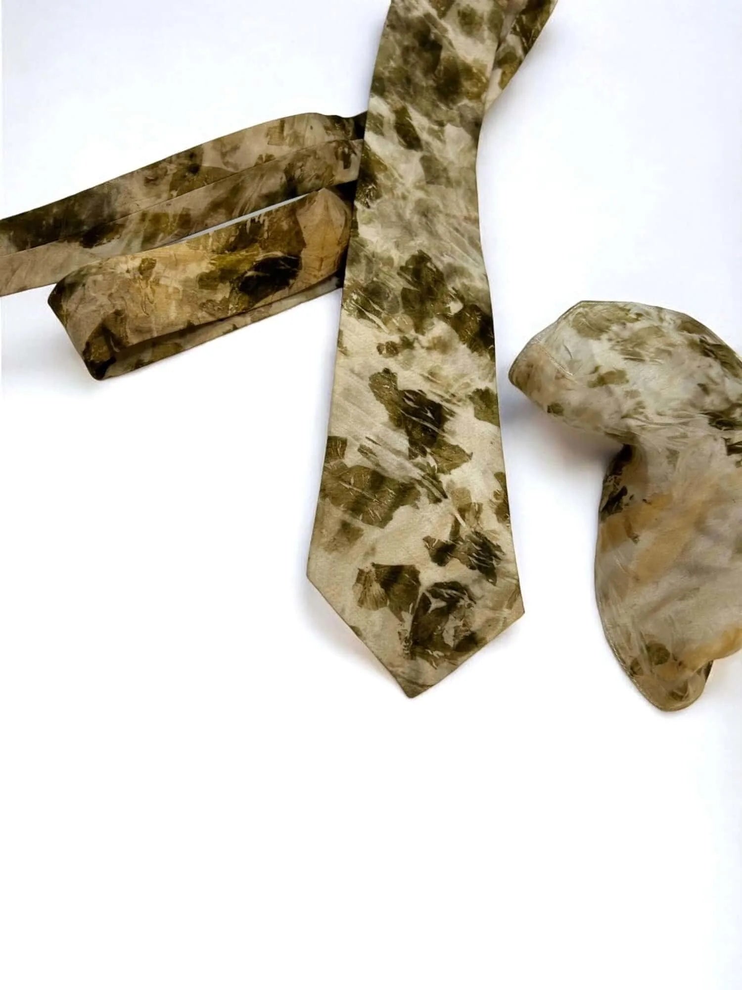 Camouflage-patterned tie and pocket square on a white background
