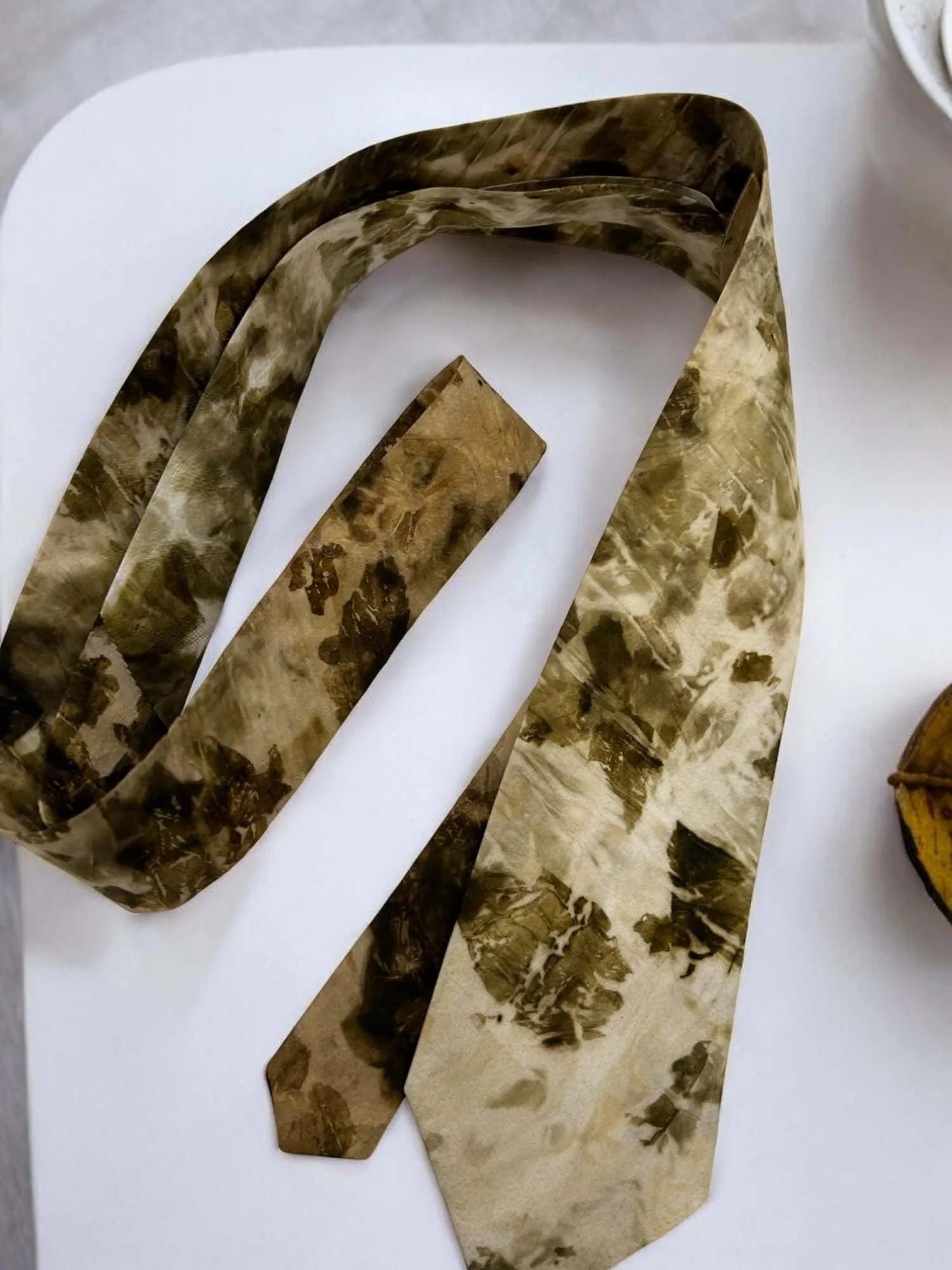 Camouflage-patterned tie on a white surface