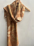 Brown and beige patterned Eco Printed Pure Silk Scarf on a wooden hanger against a light gray background