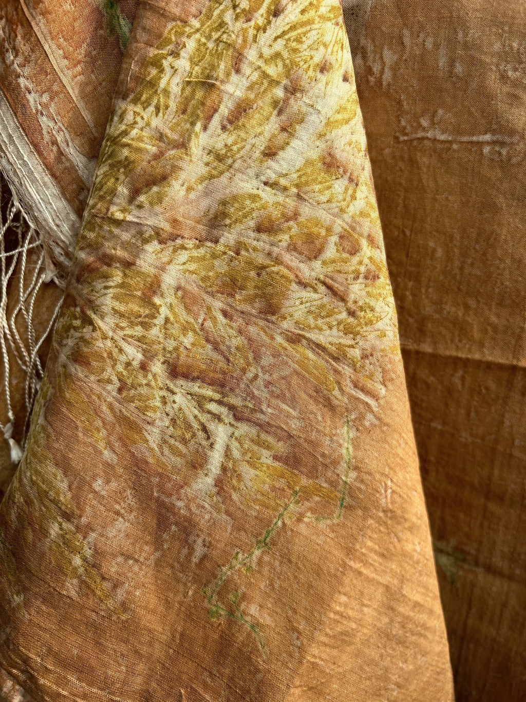 Close-up of a textured brown Coral Carnation Eco Printed Pure Silk Scarf with intricate patterns