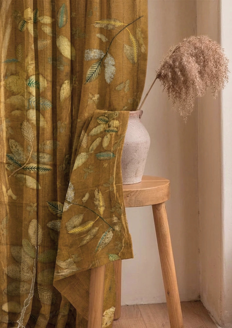 Brown Marigold dyed linen curtain with colorful embroidered leaves, handcrafted botanical home décor and sustainable window treatment curtain with a wooden stool and vase in a room setting