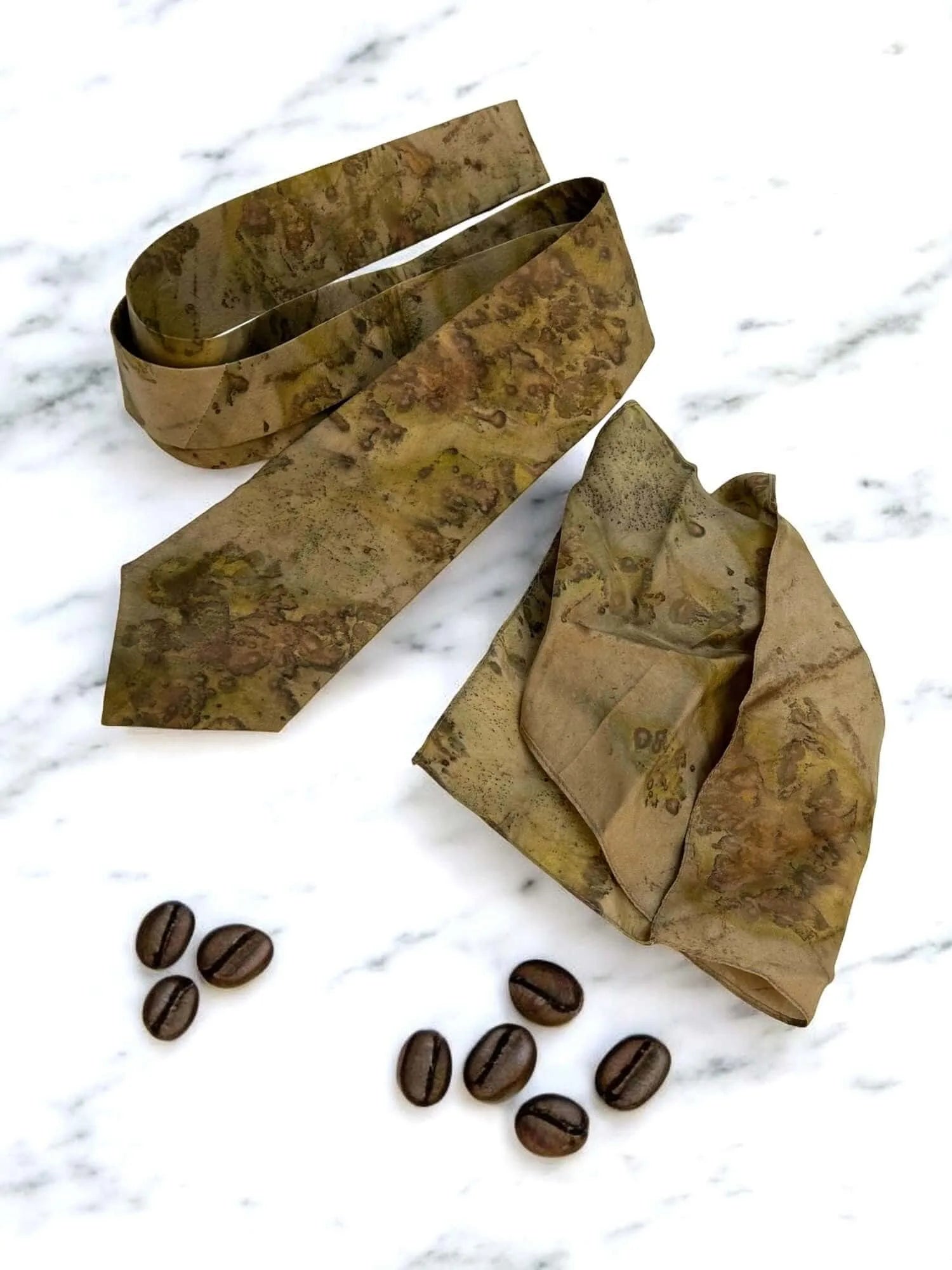 Pure silk mens tie with coffee beans on a marble surface
