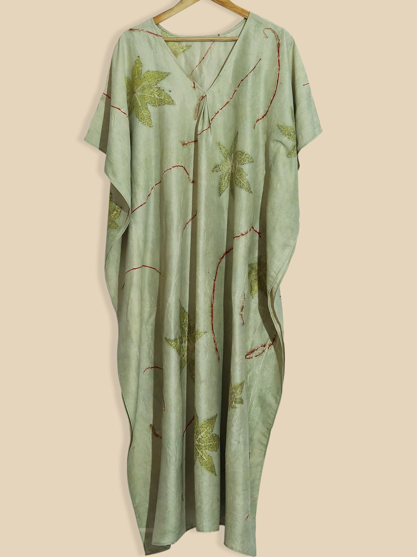 A green kaftan hanging on wall.