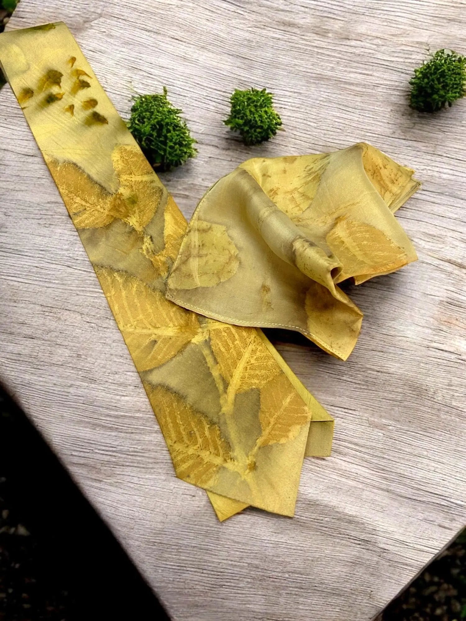 Yellow tie with leaf pattern on a wooden surface