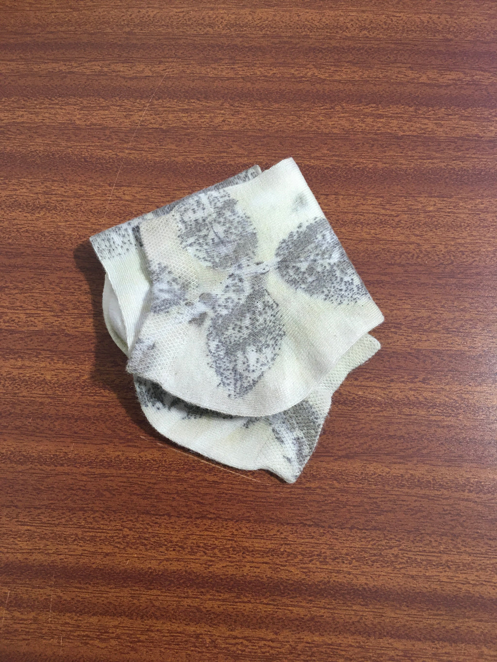 Handmade eco print socks using natural dyes and botanical imprint technique on a wooden surface