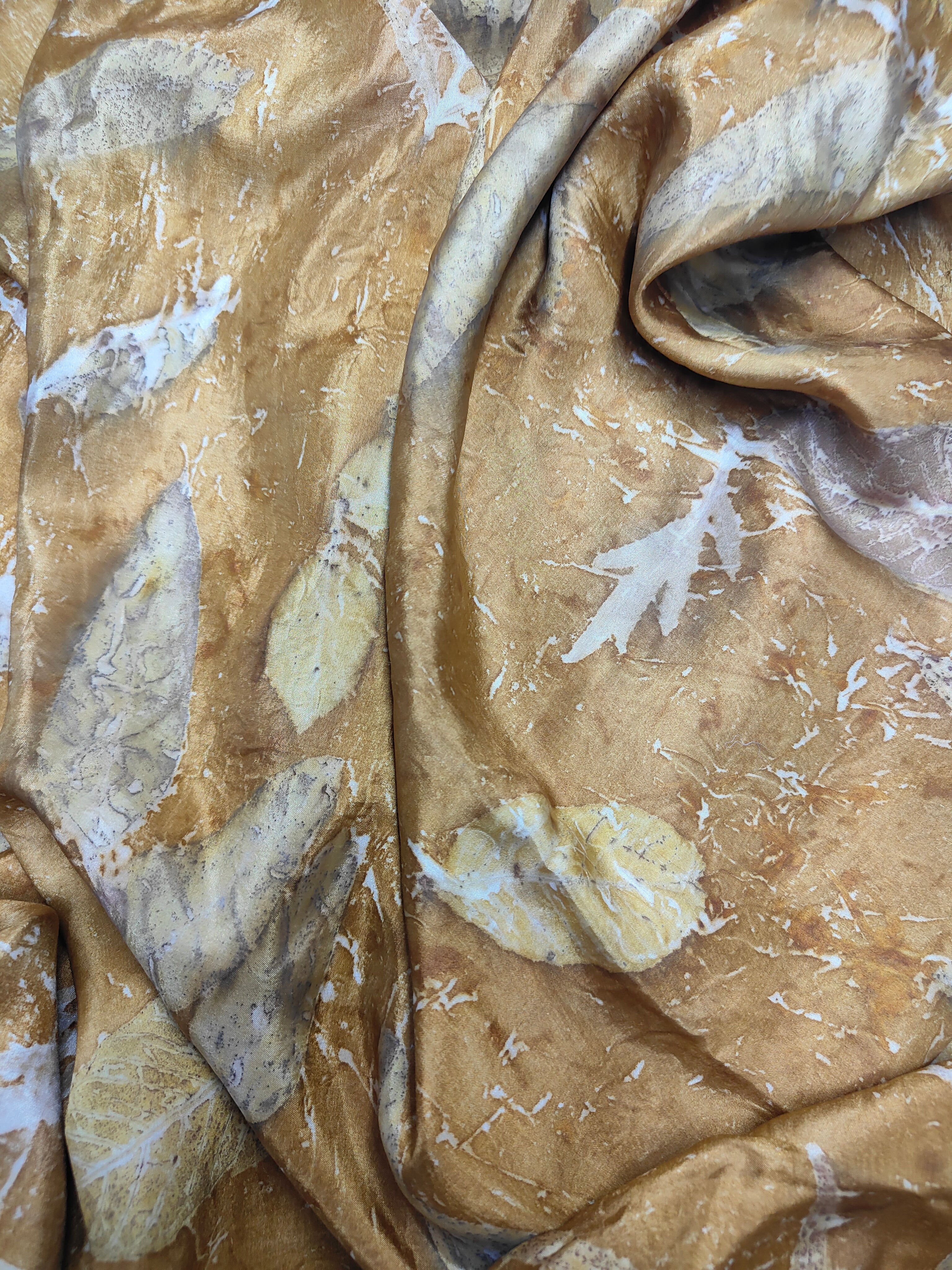 Brown silk fabric with eco-printed loose leaves.