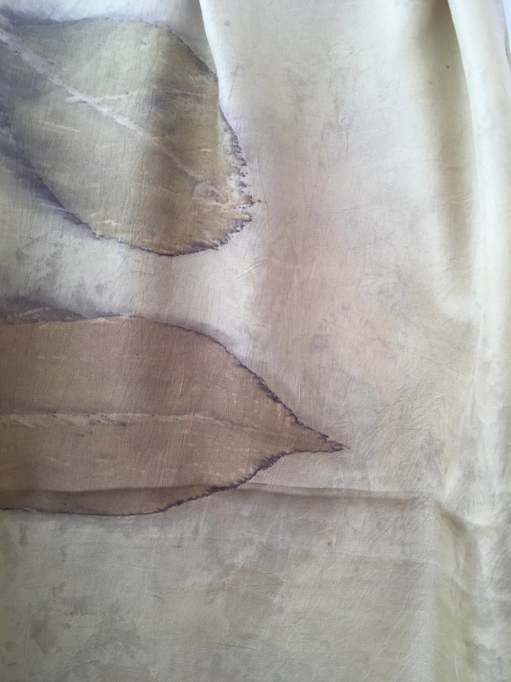 Close-up of a textured beige fabric pure silk scarf with leaf patterns
