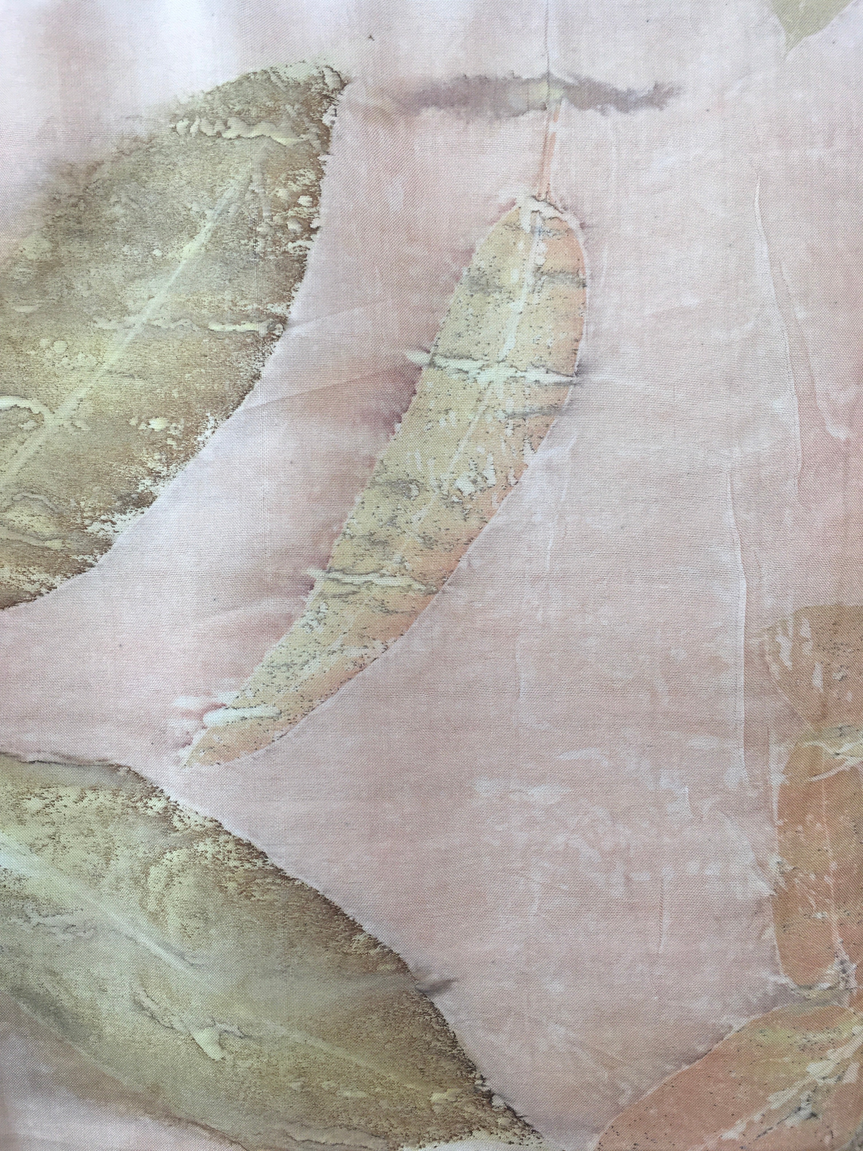 Close-up of a textured pure silk ecoprinted scarf with green leaf-like patterns