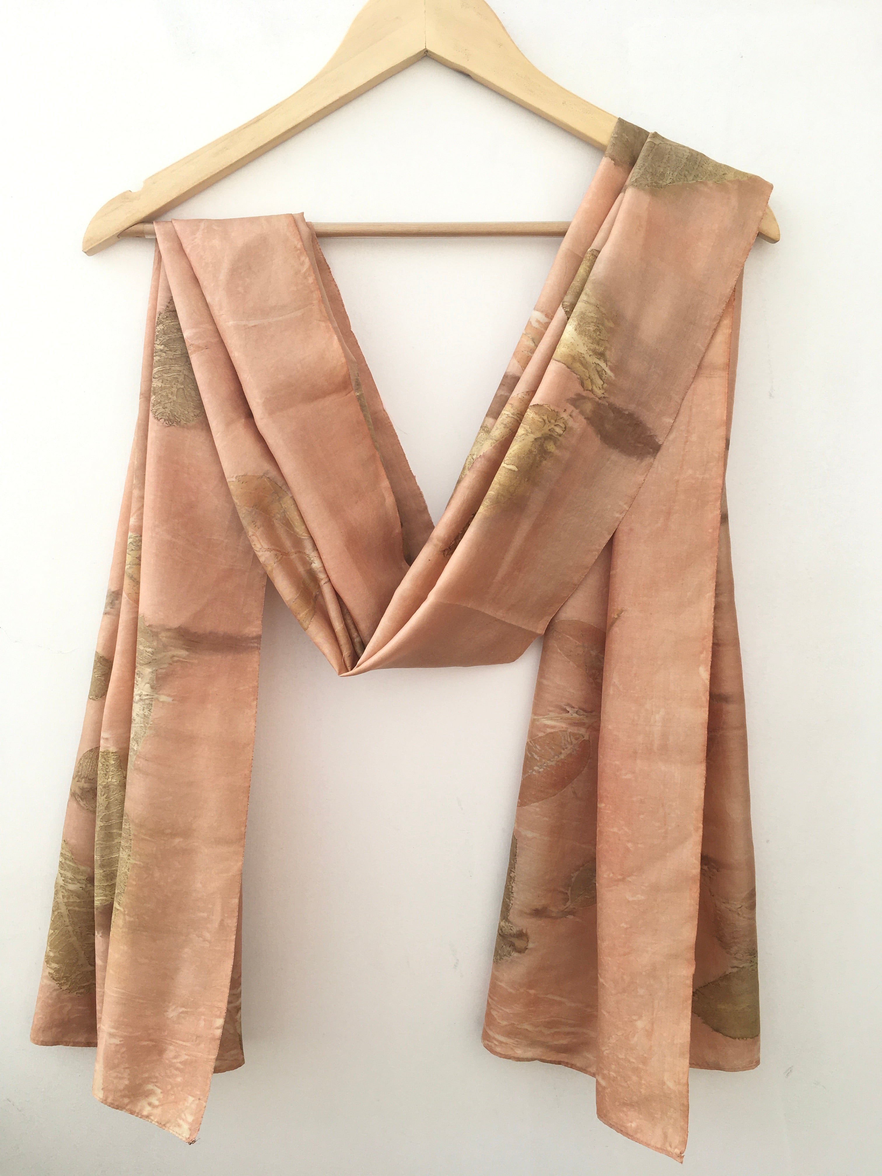 Folded pure silk ecoprinted scarf on a white background