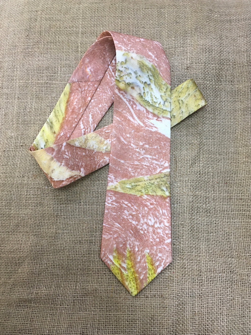 pure Silk tie with pink and green pattern on a textured brown background