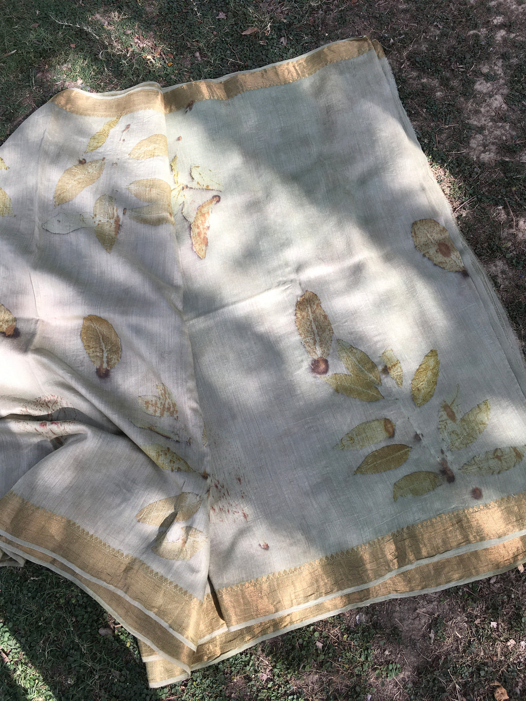 Ecoprinted Matka Silk Saree  with gold leaf patterns on a textured surface