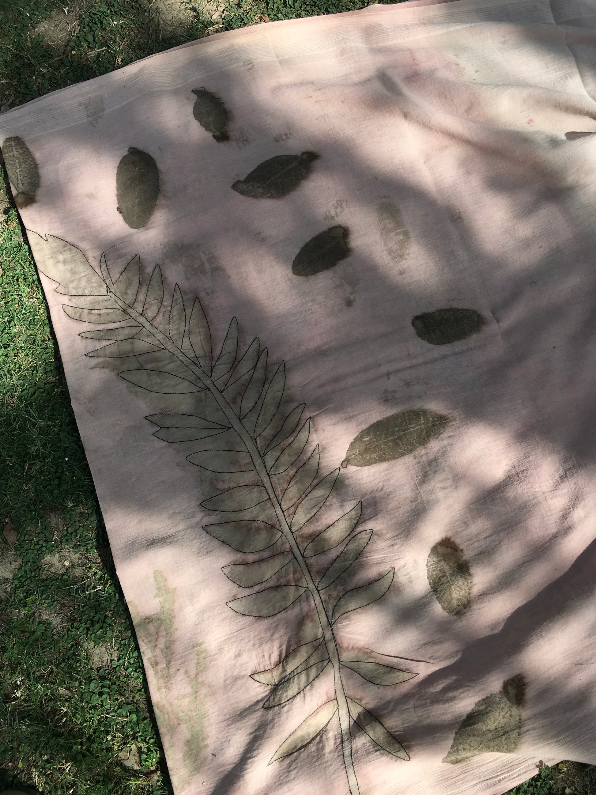 ecoprinted cotton saree with leaf patterns on a grassy background