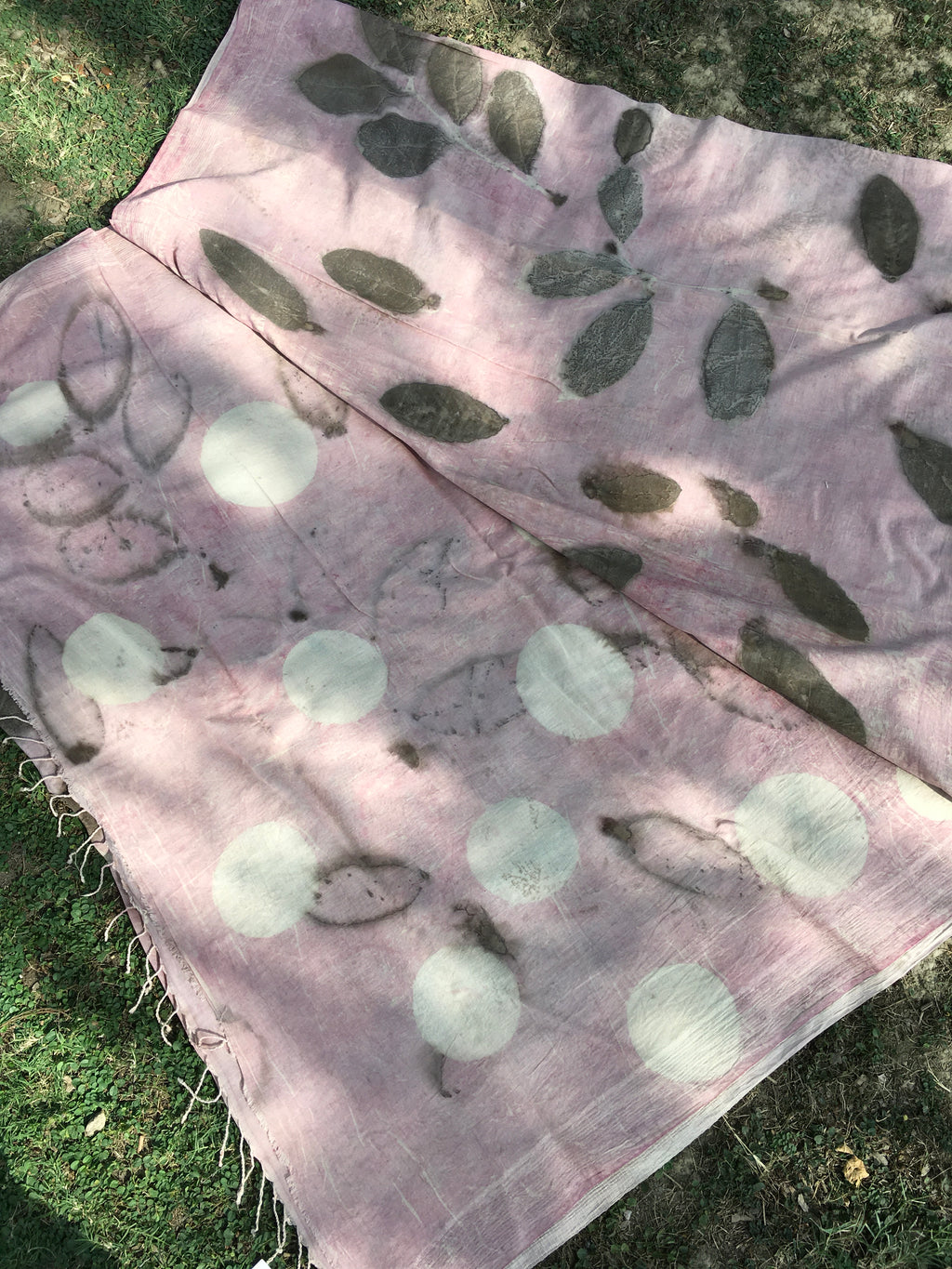 mulmul cotton ecoprinted saree with leaf and circle patterns on a grassy background