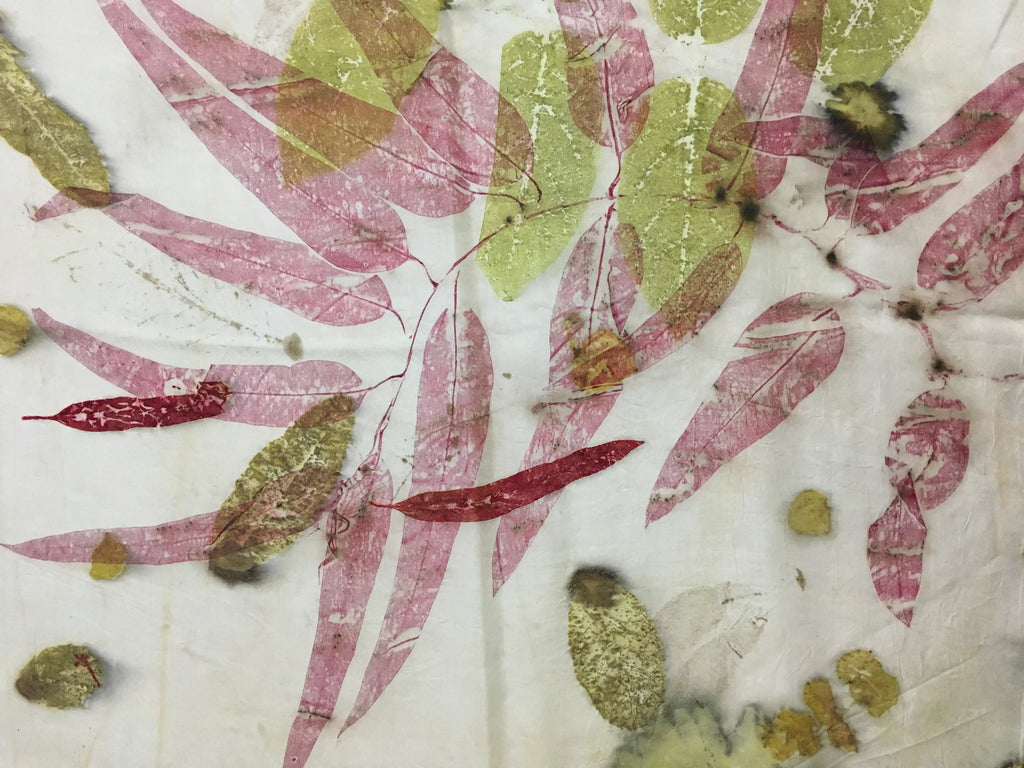 Handcrafted pure silk scarf featuring eco-printed botanical leaves and crimson madder leaf prints on a white silk background using natural dyeing techniques.