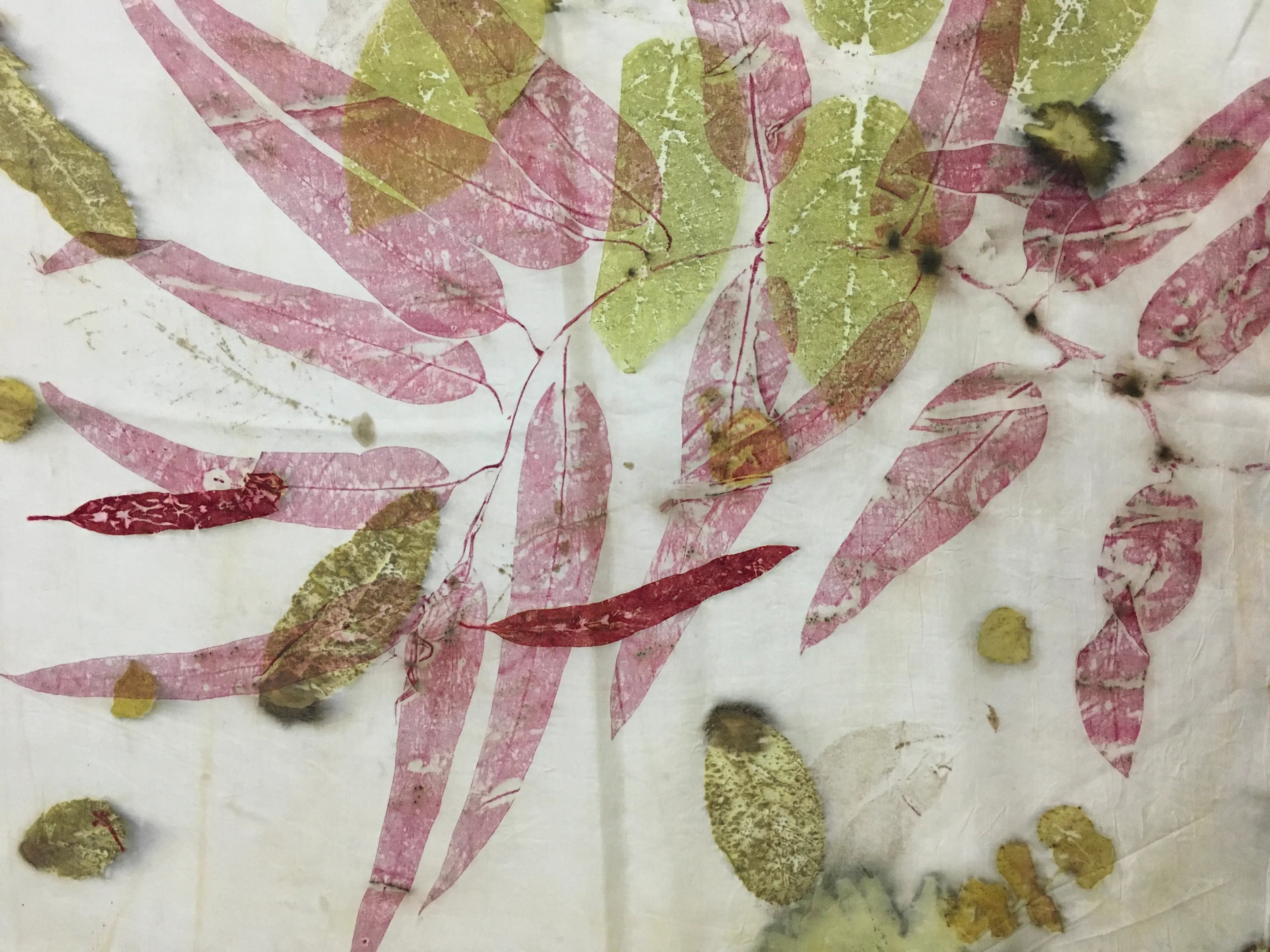 Handcrafted pure silk scarf featuring eco-printed botanical leaves and crimson madder leaf prints on a white silk background using natural dyeing techniques.