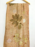 Handcrafted pure silk scarf featuring eco-printed guava leaves surrounding a moon-inspired white circular design, created using natural dyes and sustainable botanical printing techniques.