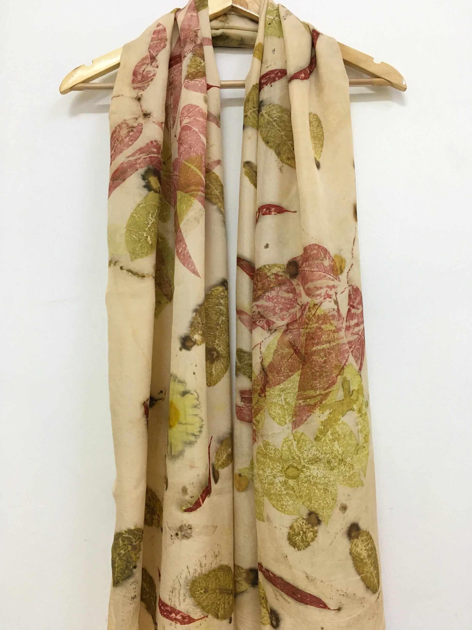 Floral patterned Madder Leaf Eco Printed Pure Silk Scarf on a wooden hanger against a white background
