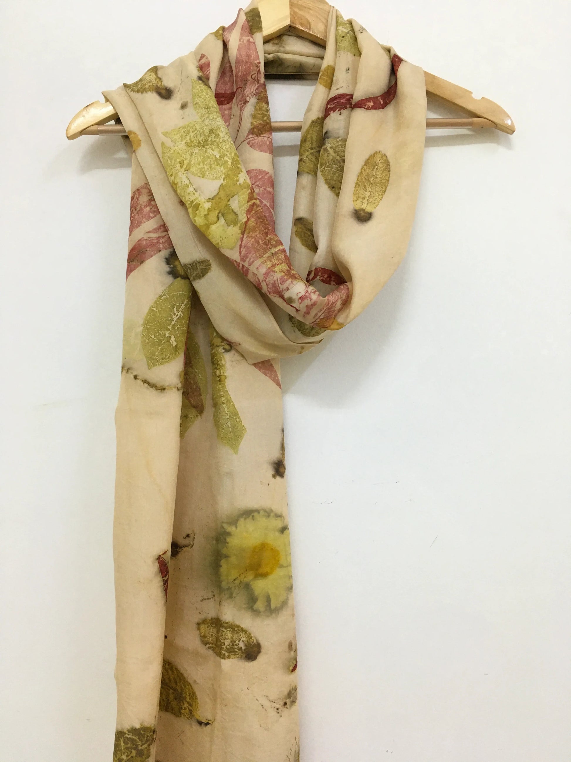 Floral patterned Madder Leaf Eco Printed Pure Silk Scarf on a wooden hanger against a white background