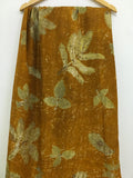 Pure silk Ecoprinted Brown fabric with green leaf pattern on a wooden hanger against a white background