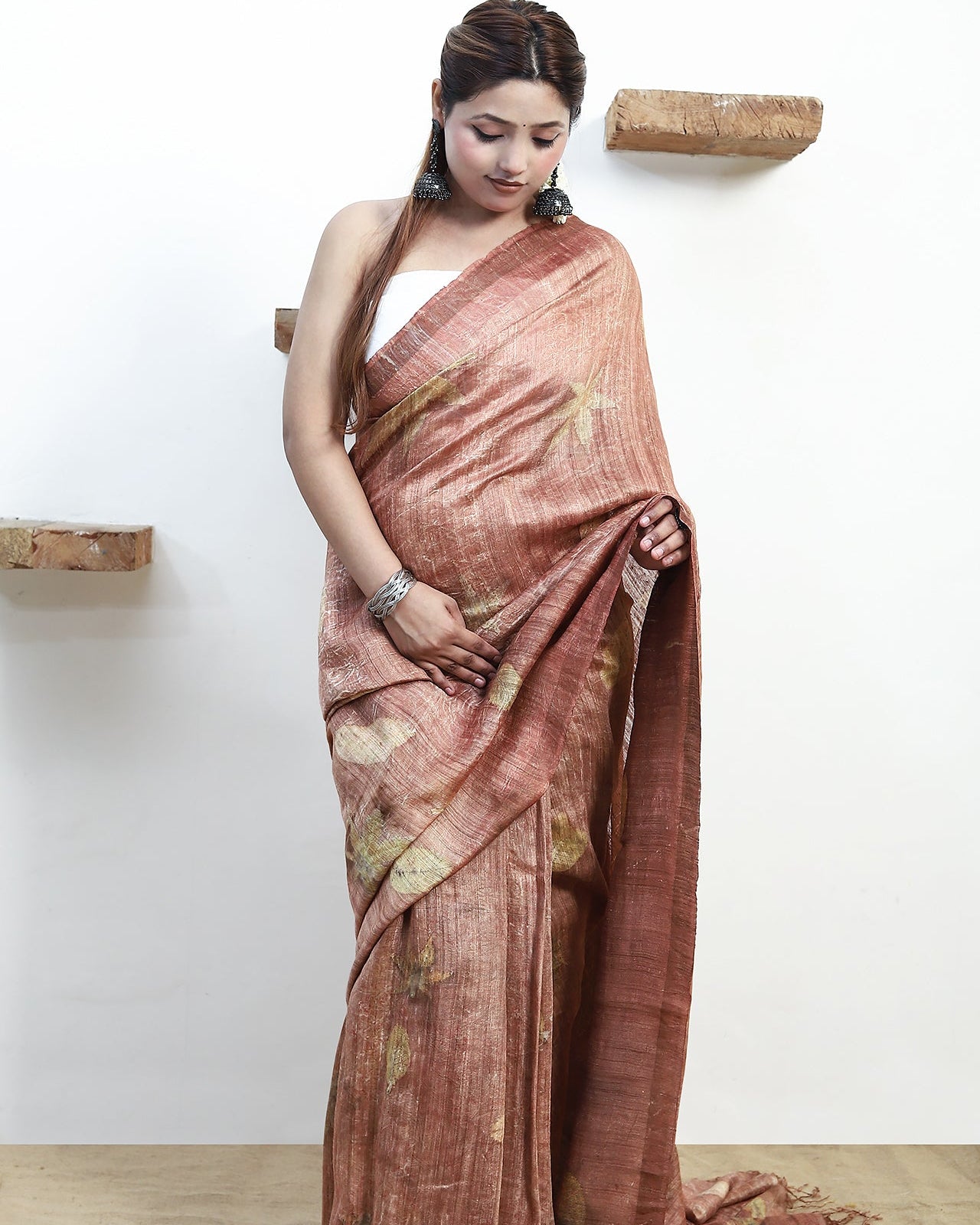 Woman wearing a pure matka silk saree with a white background