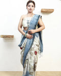 Woman wearing a pure matka silk saree with an ecoprinted saree against a white wall.