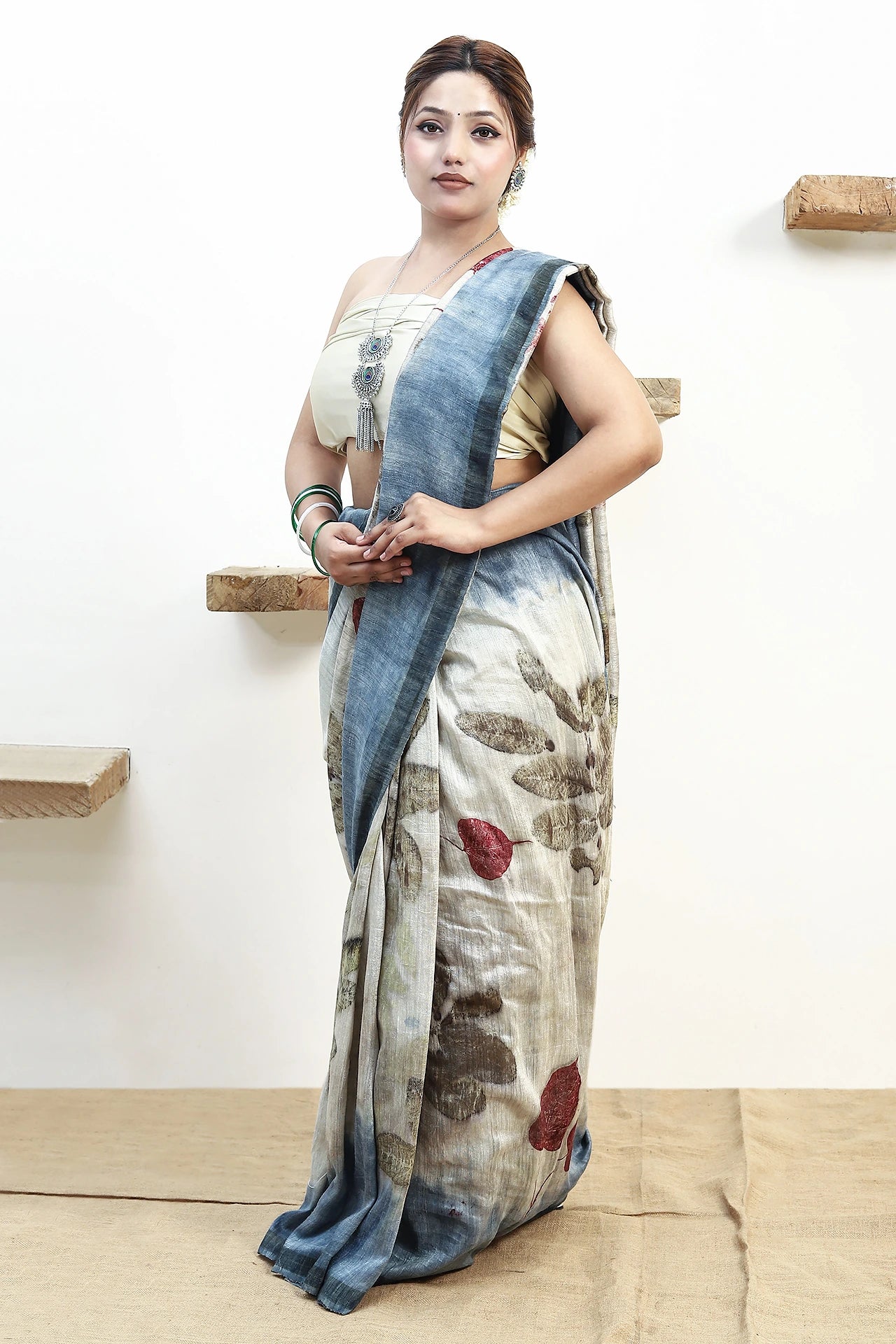 Woman wearing a pure matka silk ecoprinted saree against a white background