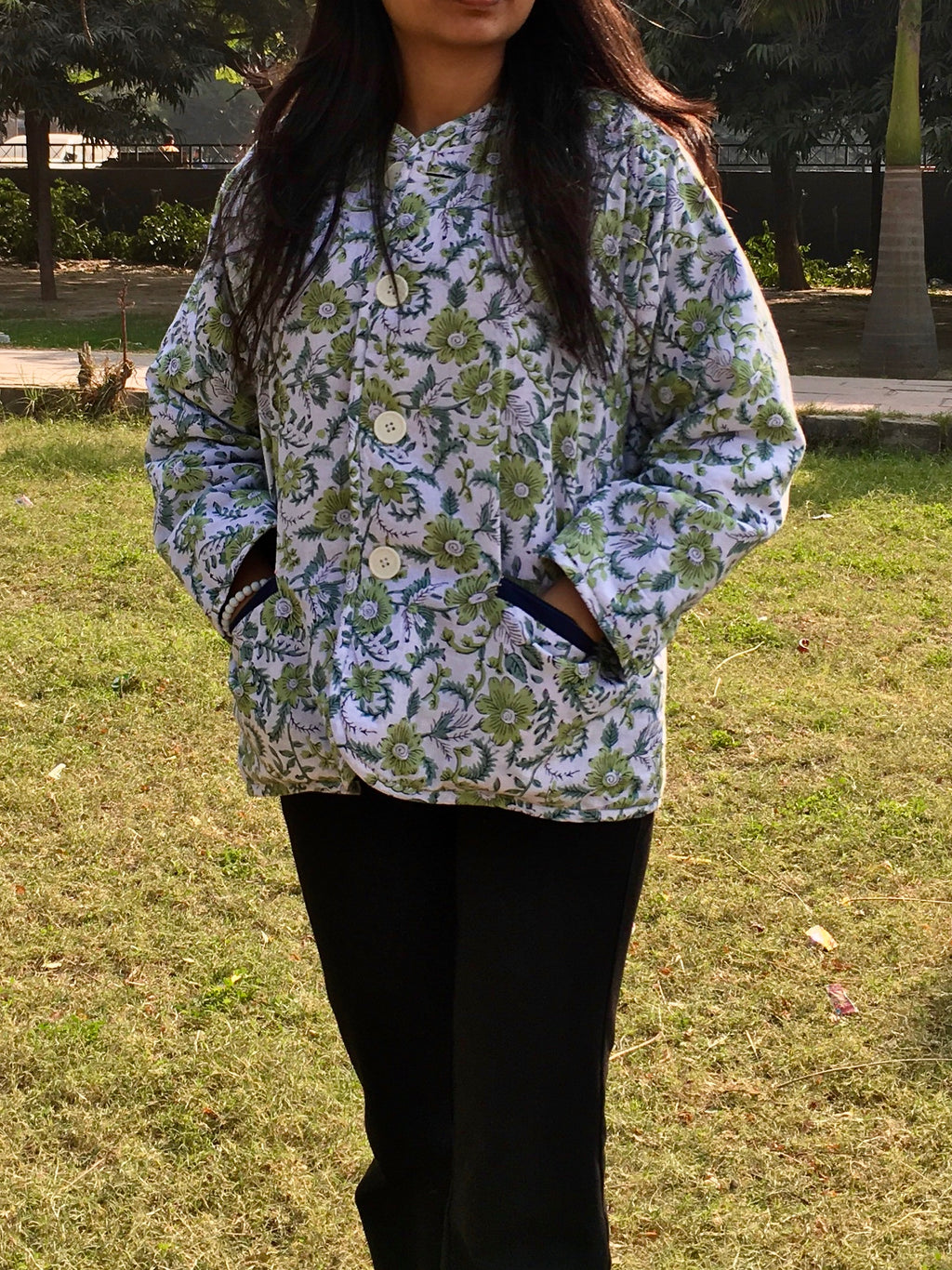 women wearing a floral patterned reversible jacket outdoors on grass