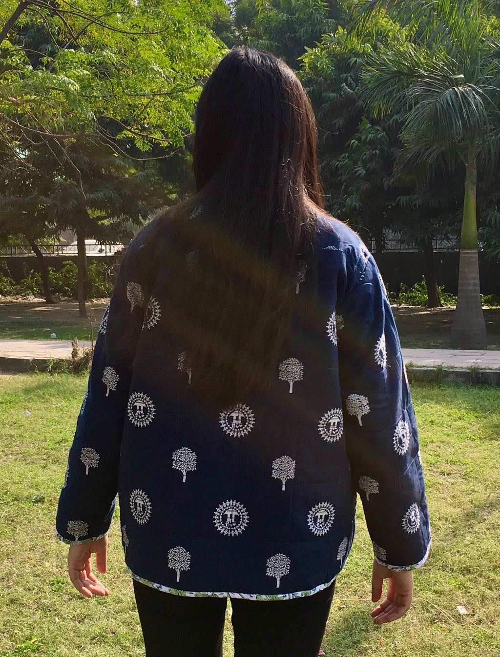 women wearing a navy blue reversible jacket with white patterns in an outdoor setting