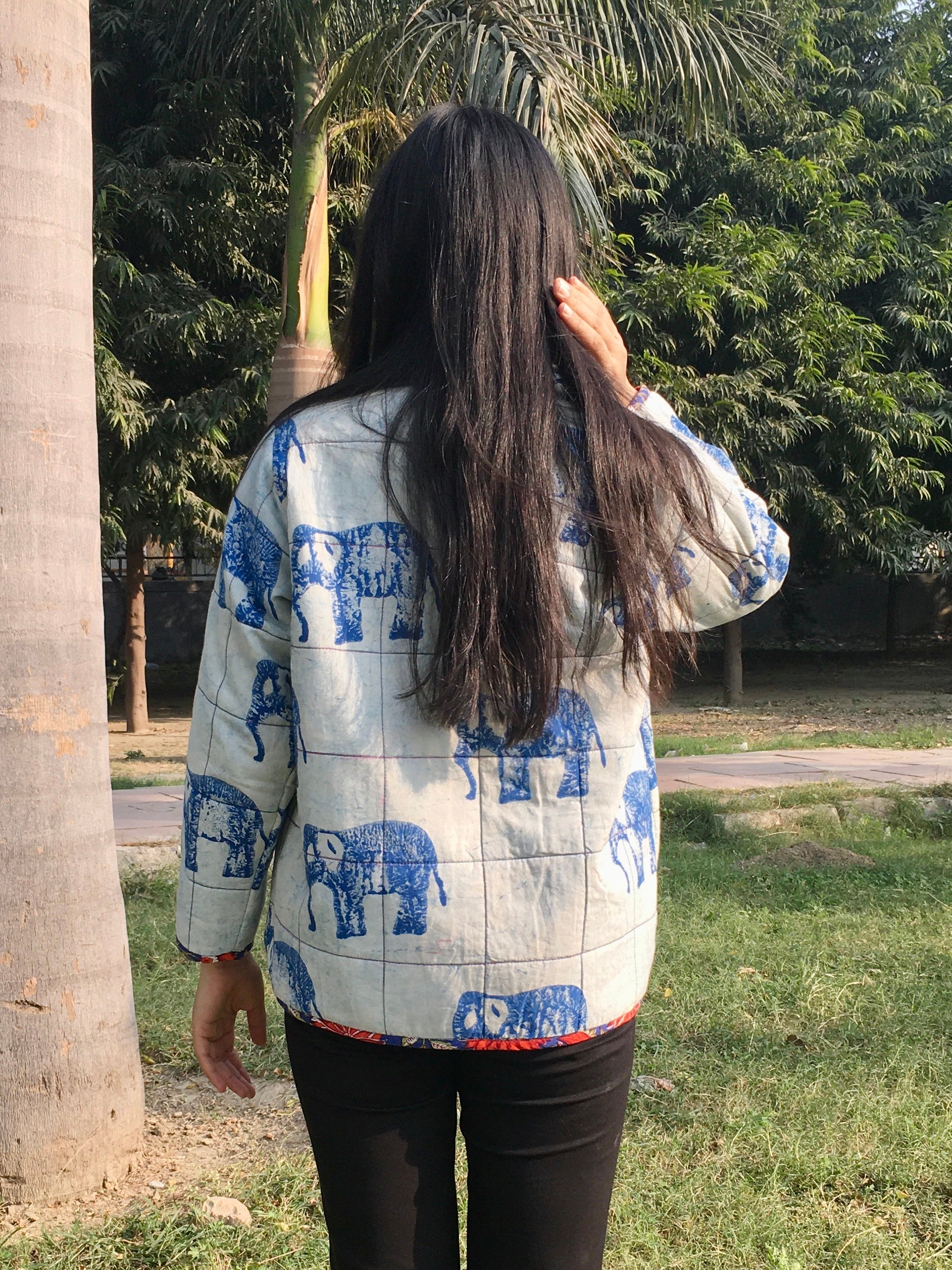 women wearing a reversible jacket with blue elephant patterns outdoors