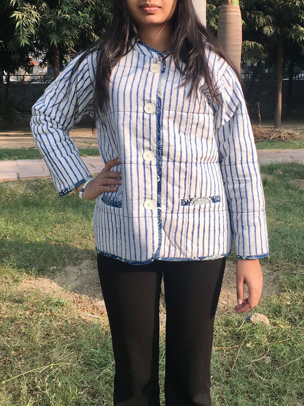 women wearing a blue and white striped reversible jacket outdoors