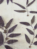 Handcrafted pure silk scarf featuring eco-printed eucalyptus leaves in natural logwood purple on a white silk background, created using sustainable botanical dyeing techniques.