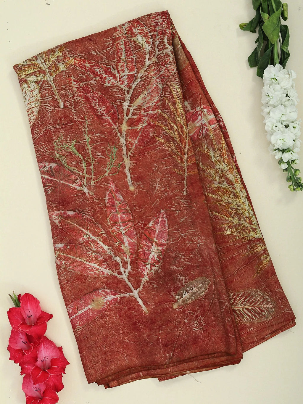 A pure silk red saree ecoprinted with seasonal leaves