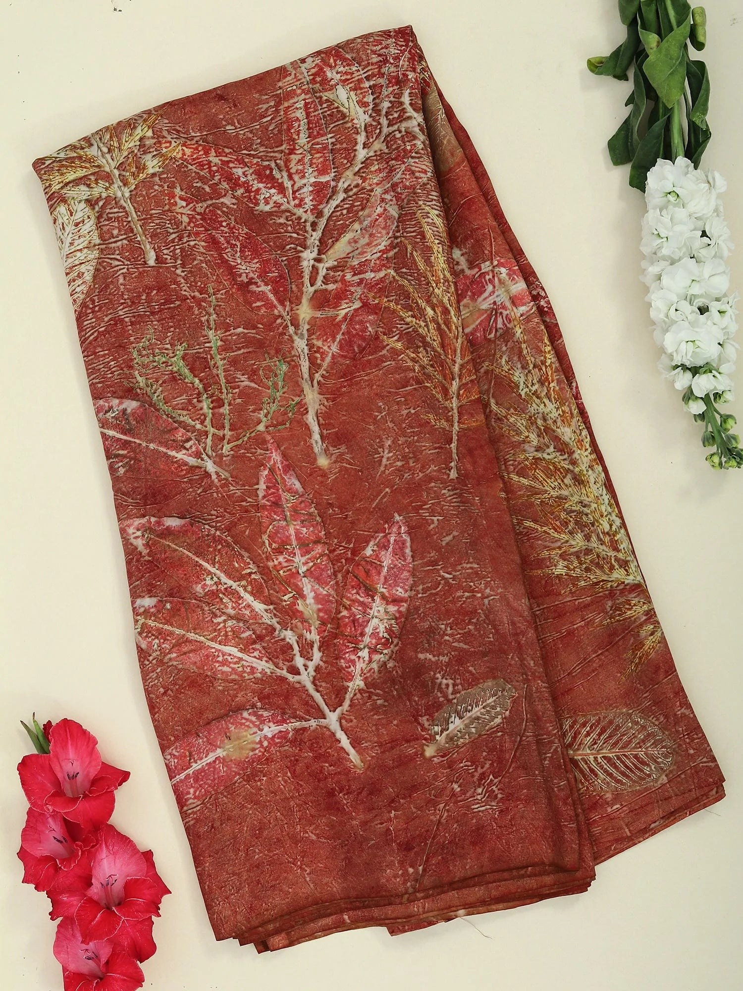 A pure silk red saree ecoprinted with seasonal leaves