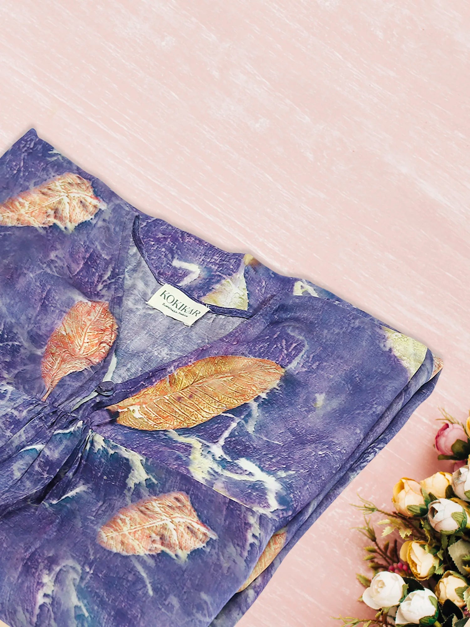 Blue ecoprinted kaftan folded on pink floor