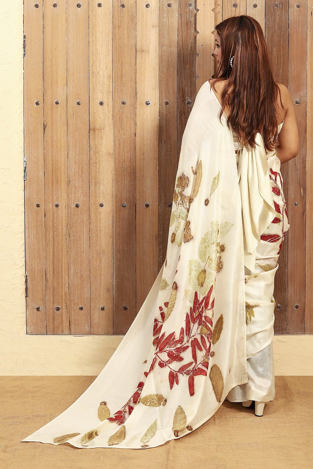 Woman wearing a Opal Essence Ecoprinted Pure Silk saree against a wooden panel background