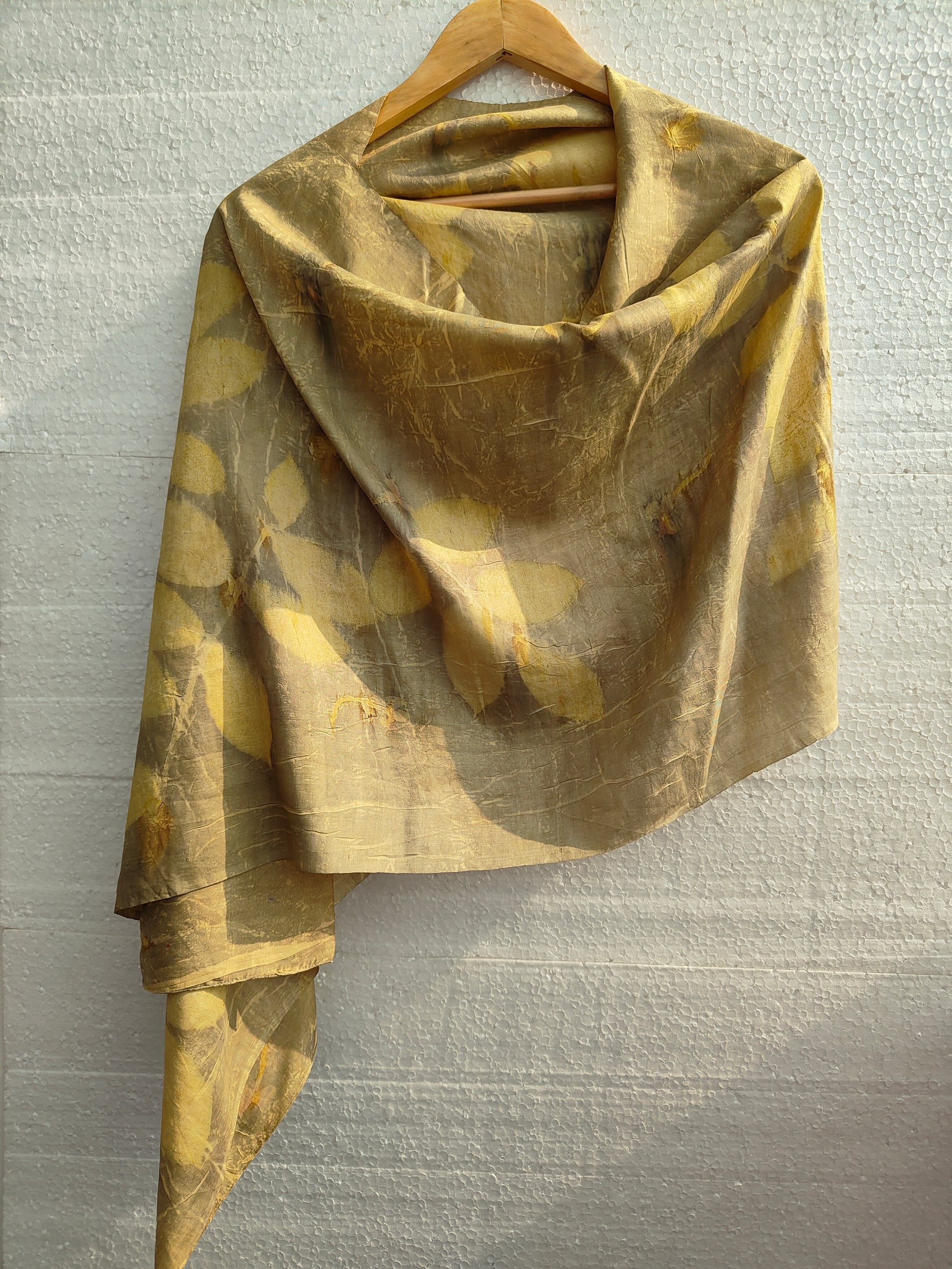 An ecoprinted green silk scarf