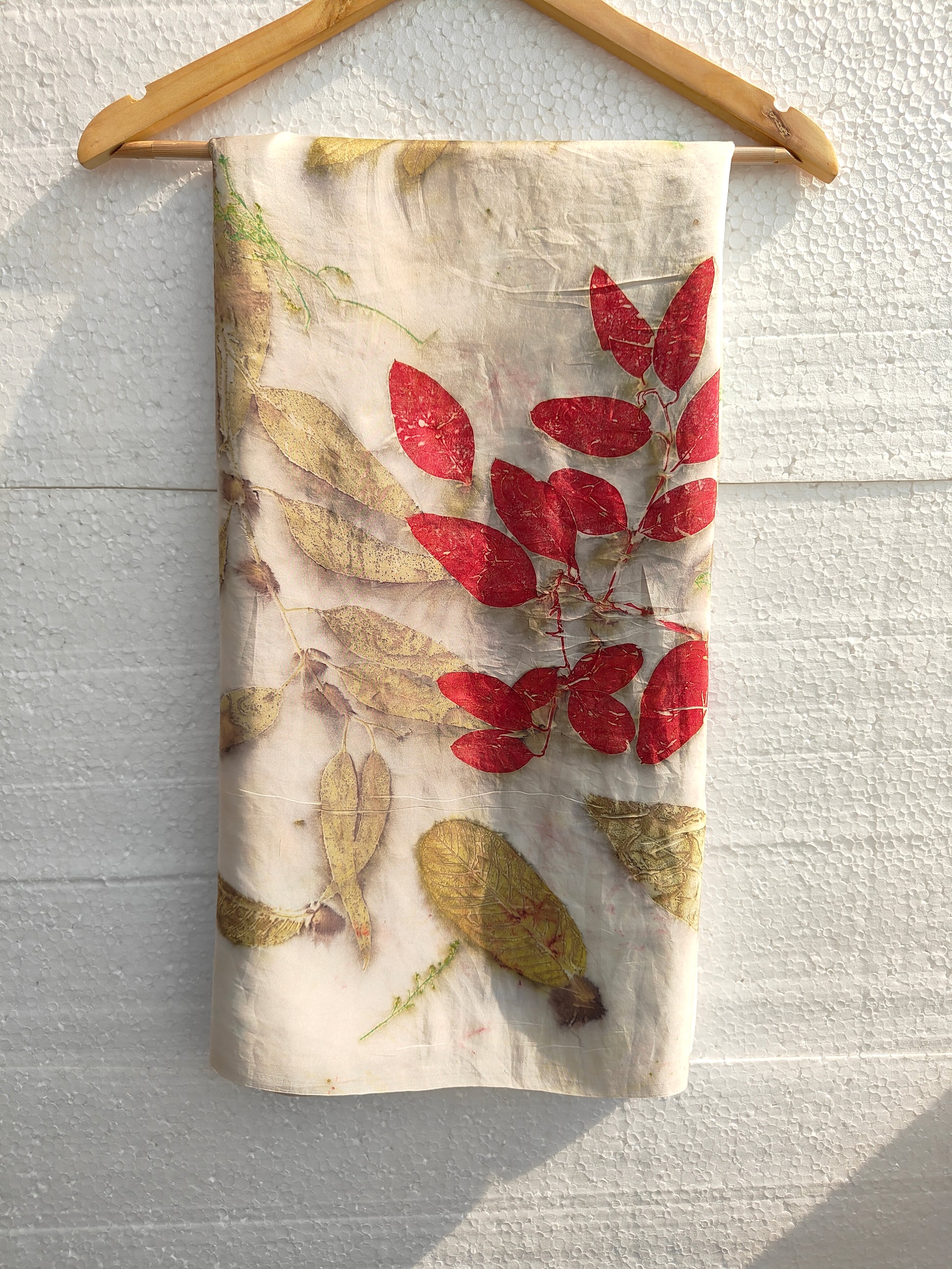 A folded white ecoprinted saree