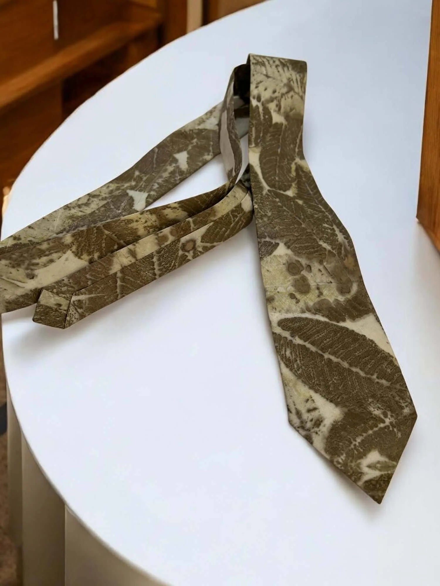 Patterned mens silk tie on a white surface