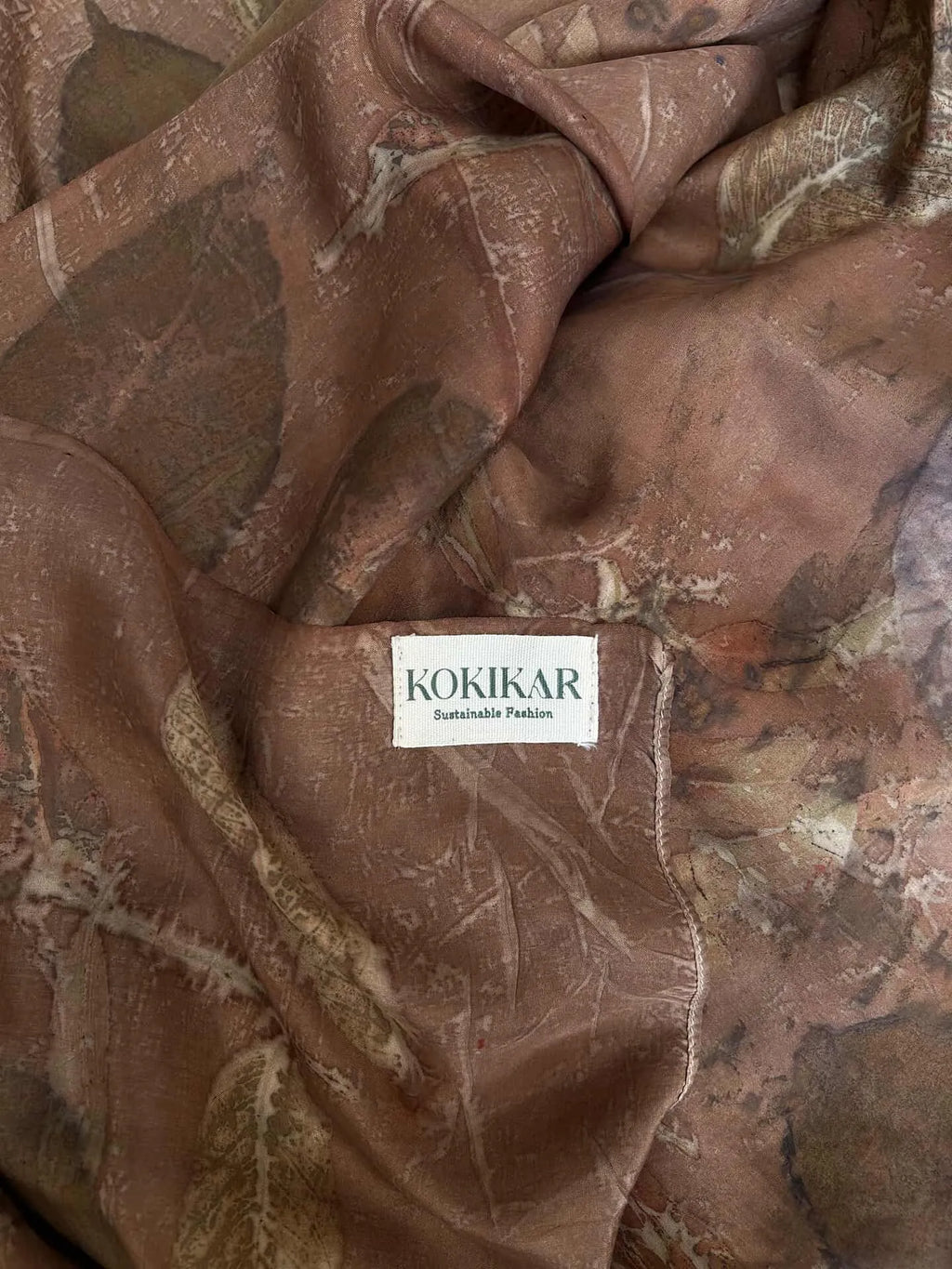 Brown Handcrafted pure silk scarf naturally dyed with catechu and eco printed with seasonal leaves and mixed botanical plants, featuring rich dark brown earthy tones and sustainable artisan craftsmanship.