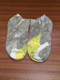 Pair of ecorpinted socks with guava leaves and turmeric (haldi) on a wooden surface