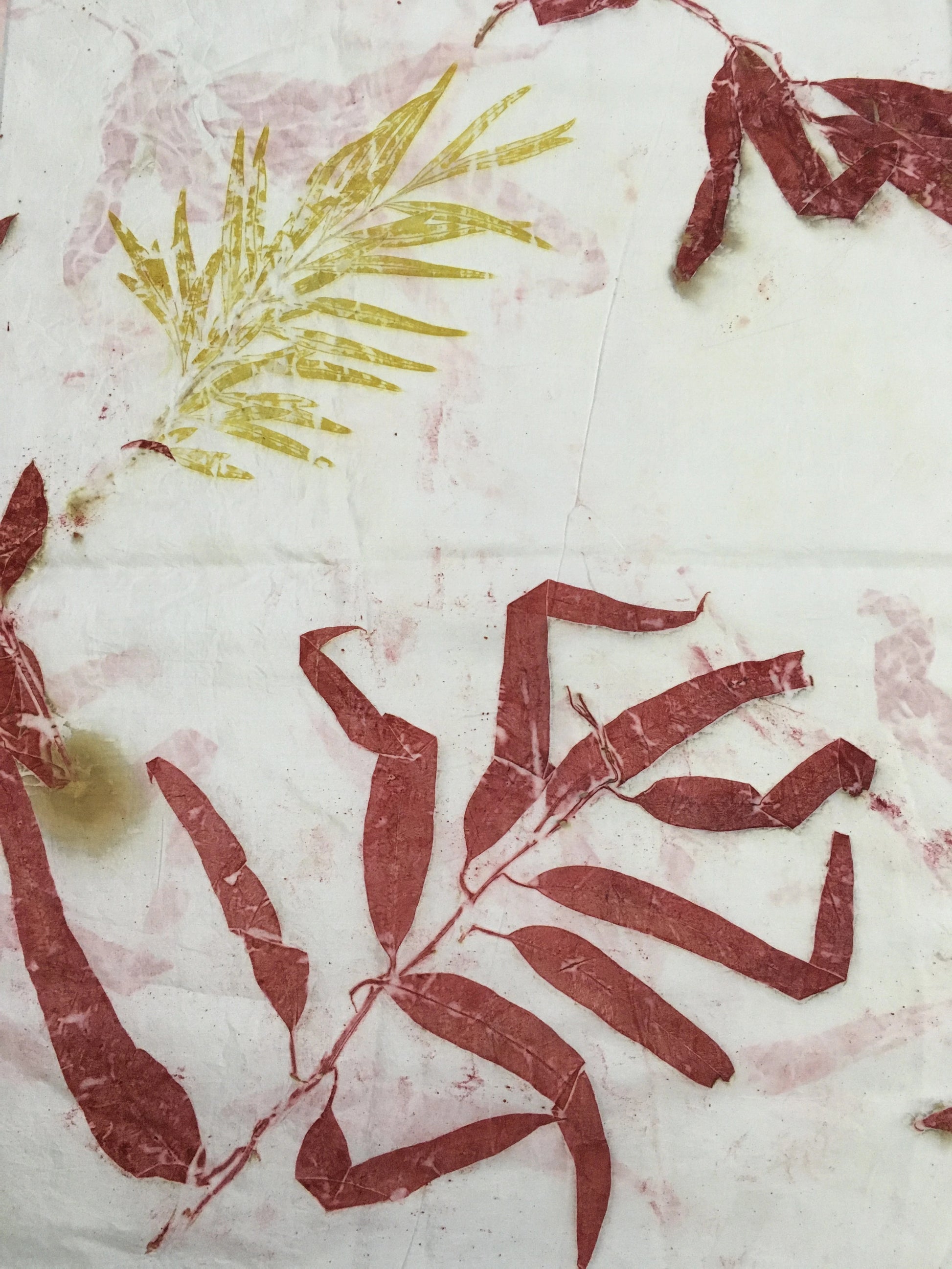 Handcrafted pure silk scarf featuring eco-printed red eucalyptus leaves and botanical shrub patterns on a white background, created using natural dyes and sustainable eco-printing techniques.
