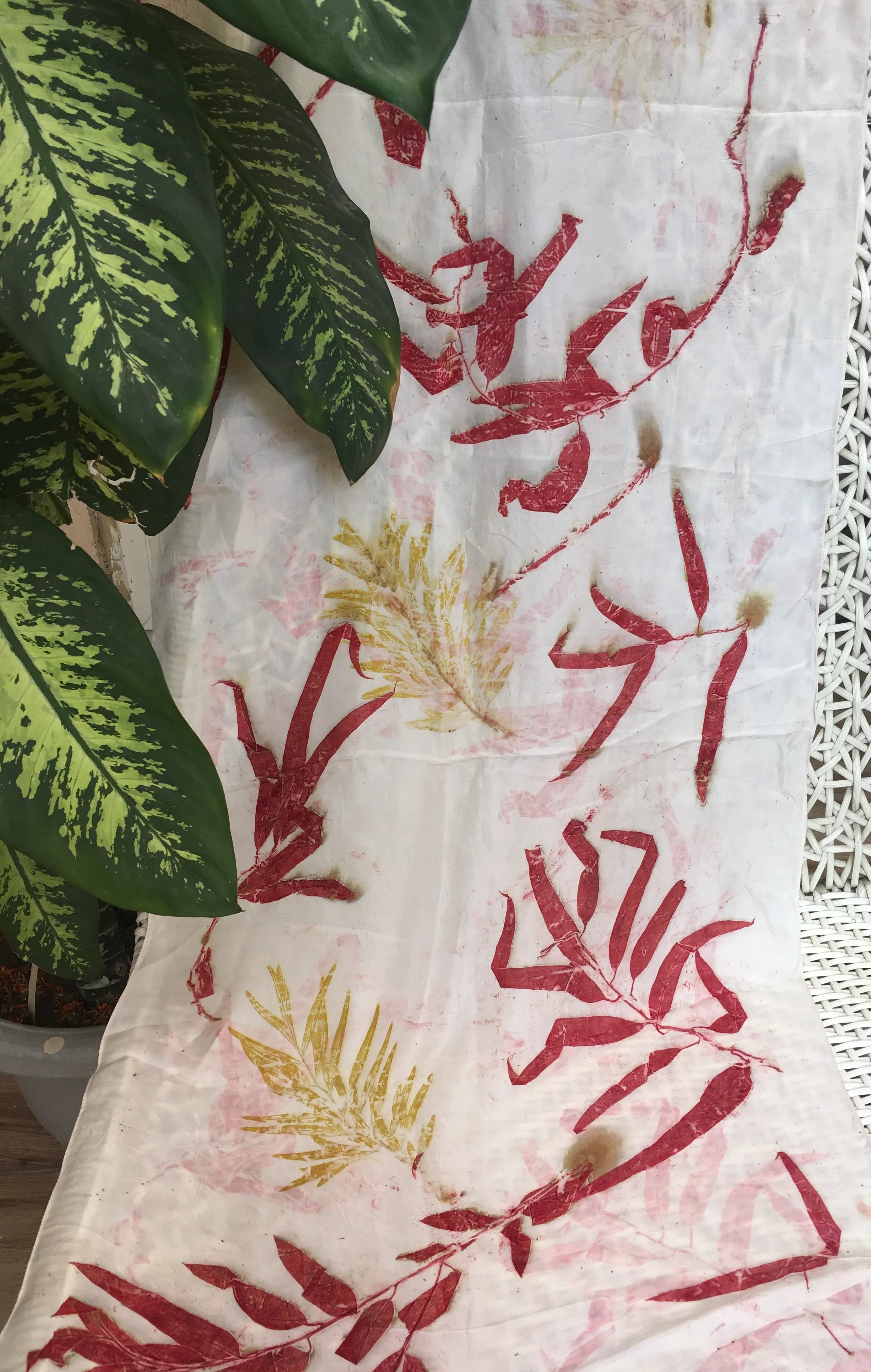 Eco printed pure silk scarf with crimson eucalyptus leaf prints and natural botanical patterns on white silk fabric.