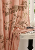 Pink curtain with leaf pattern Meadow eco-printed linen curtain naturally dyed with sappanwood, showcasing botanical leaf prints in warm pink and earthy tones on sustainable linen fabric over a white table.