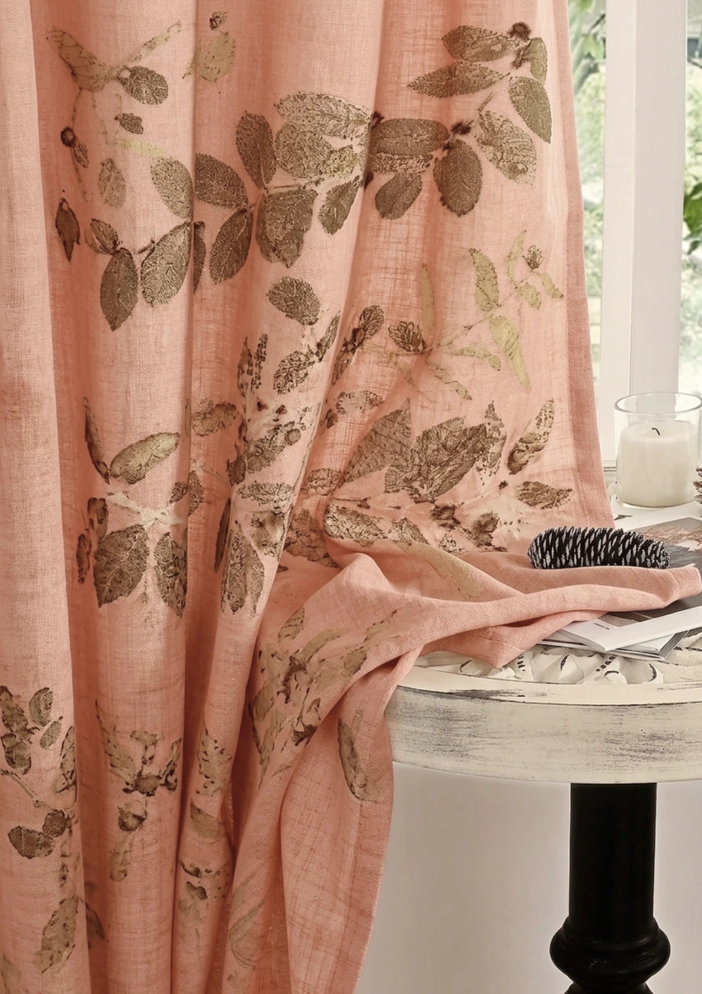 Pink curtain with leaf pattern Meadow eco-printed linen curtain naturally dyed with sappanwood, showcasing botanical leaf prints in warm pink and earthy tones on sustainable linen fabric over a white table.
