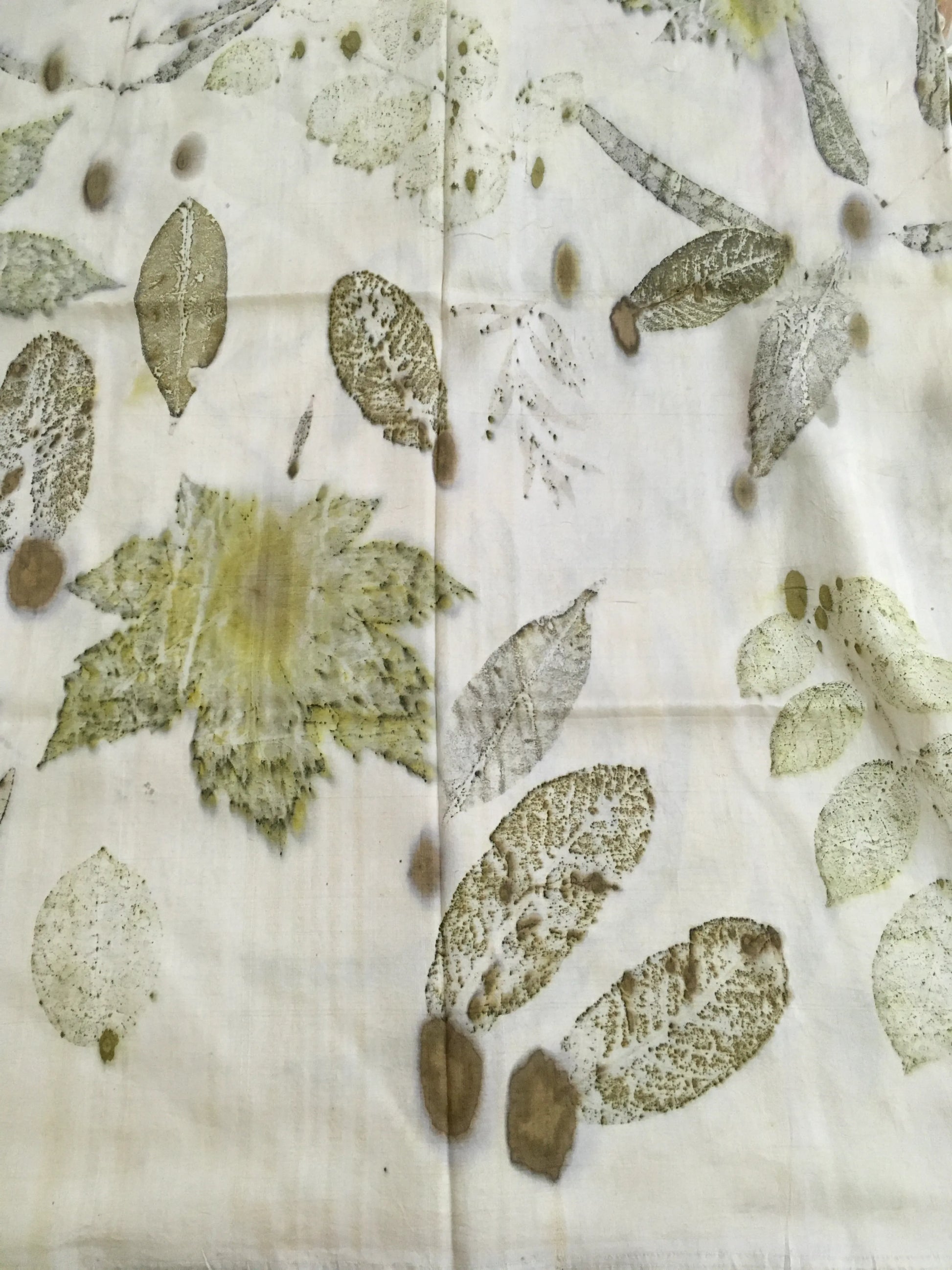 Eco printed pure silk scarf with green leaf impressions and botanical patterns created using natural dyes.